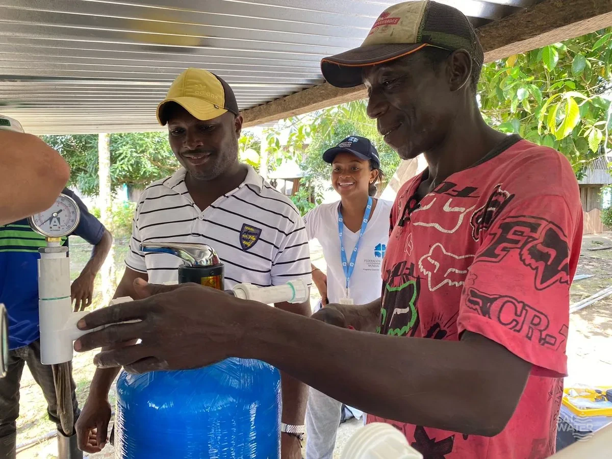Personal de SAI WATER capacitando a la comunidad en la operación de su sistema de agua